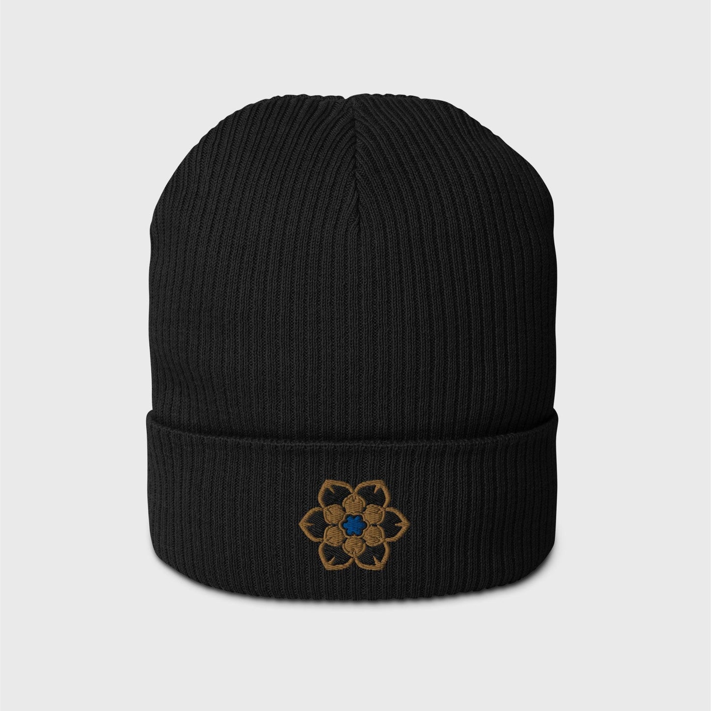 A black ribbed beanie featuring an embroidered logo in the shape of the Wanderer's hat, a gold 6 point hexagonal frame around a filled in black with another gold filled shaped inside and a blue figure in the centre.