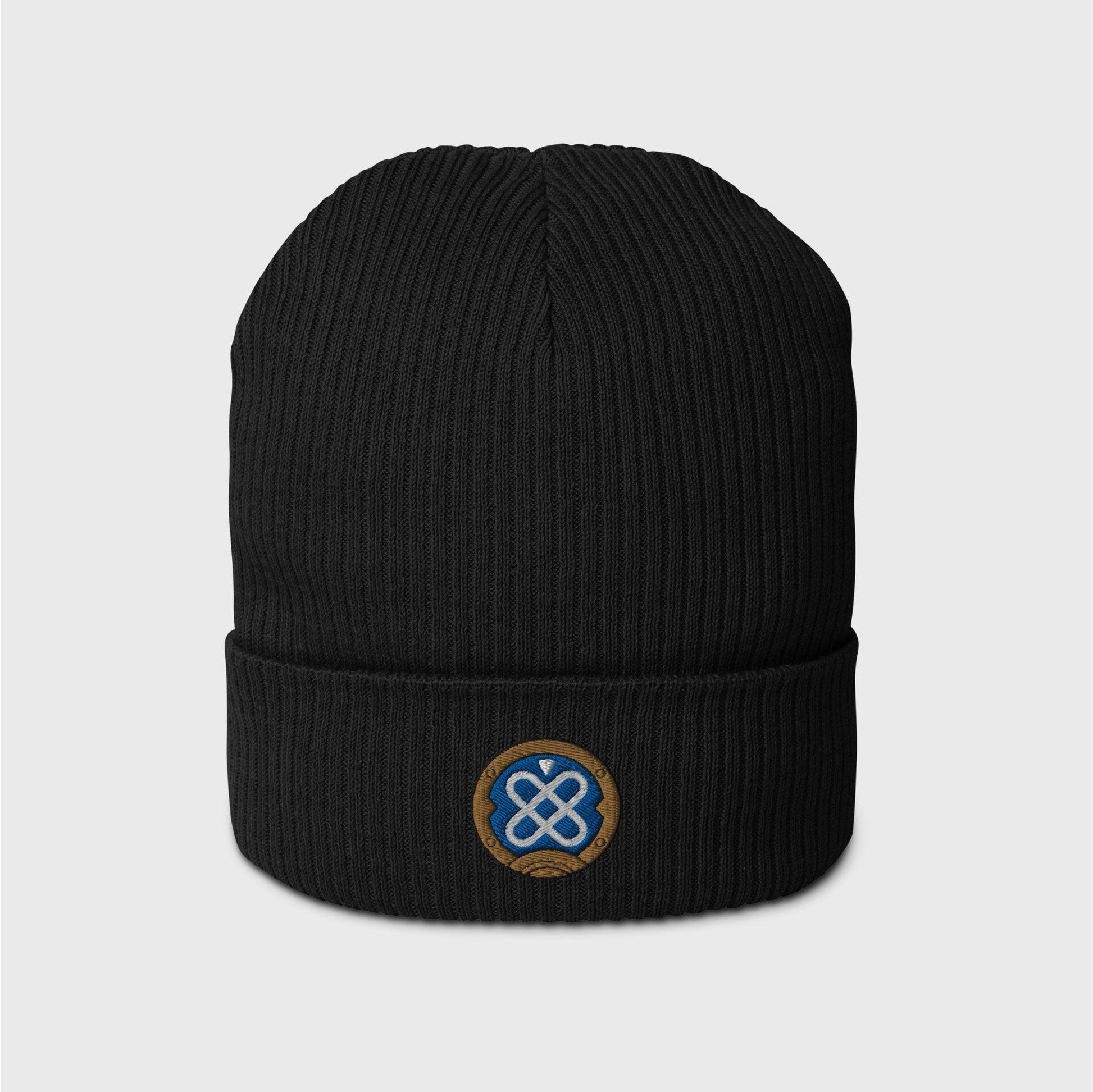 A black ribbed beanie featuring an embroidered round logo of Freminet's diving helmet, in blue with a white round shapes crossed in the centre and a round gold border around it.