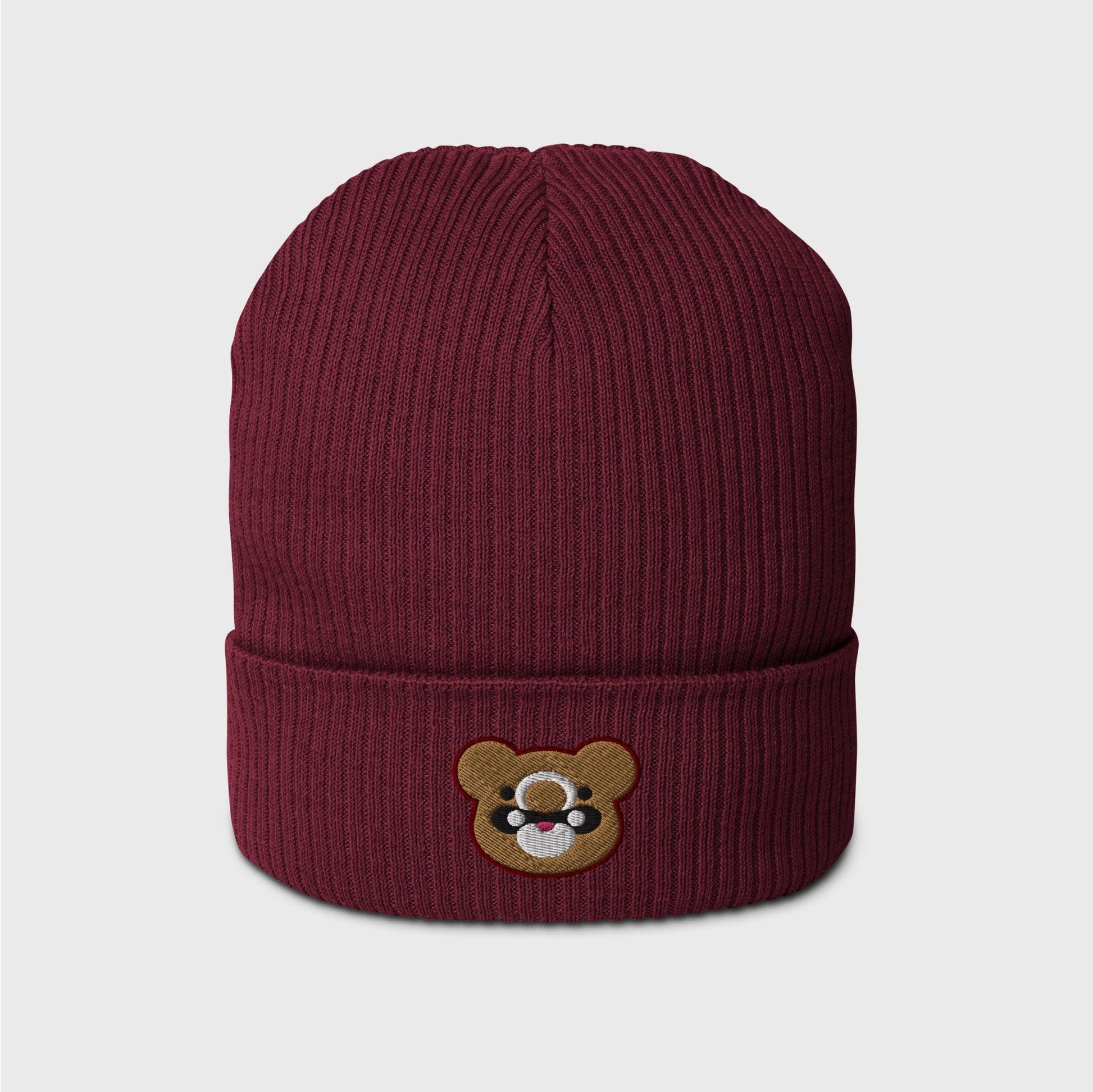 A wine red ribbed beanie featuring an embroidered bear head shape of Gouda in gold, with black and white marks and lined in dark red.