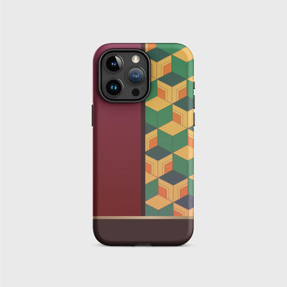 A tough iPhone case featuring Tomioka’s kimono pattern: the left side of the case is filled with a dark red, while the right side of the case is filled with a cubic pattern in greens, orange and yellow. A gold division 3/4 vertically from the bottom separates the pattern from a brown base.