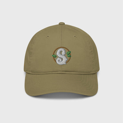 A khaki green classic cap featuring a round dark green frame enclosing a white snake in the shape of an S in the centre. Three small green leaves ornament the frame around the snake.