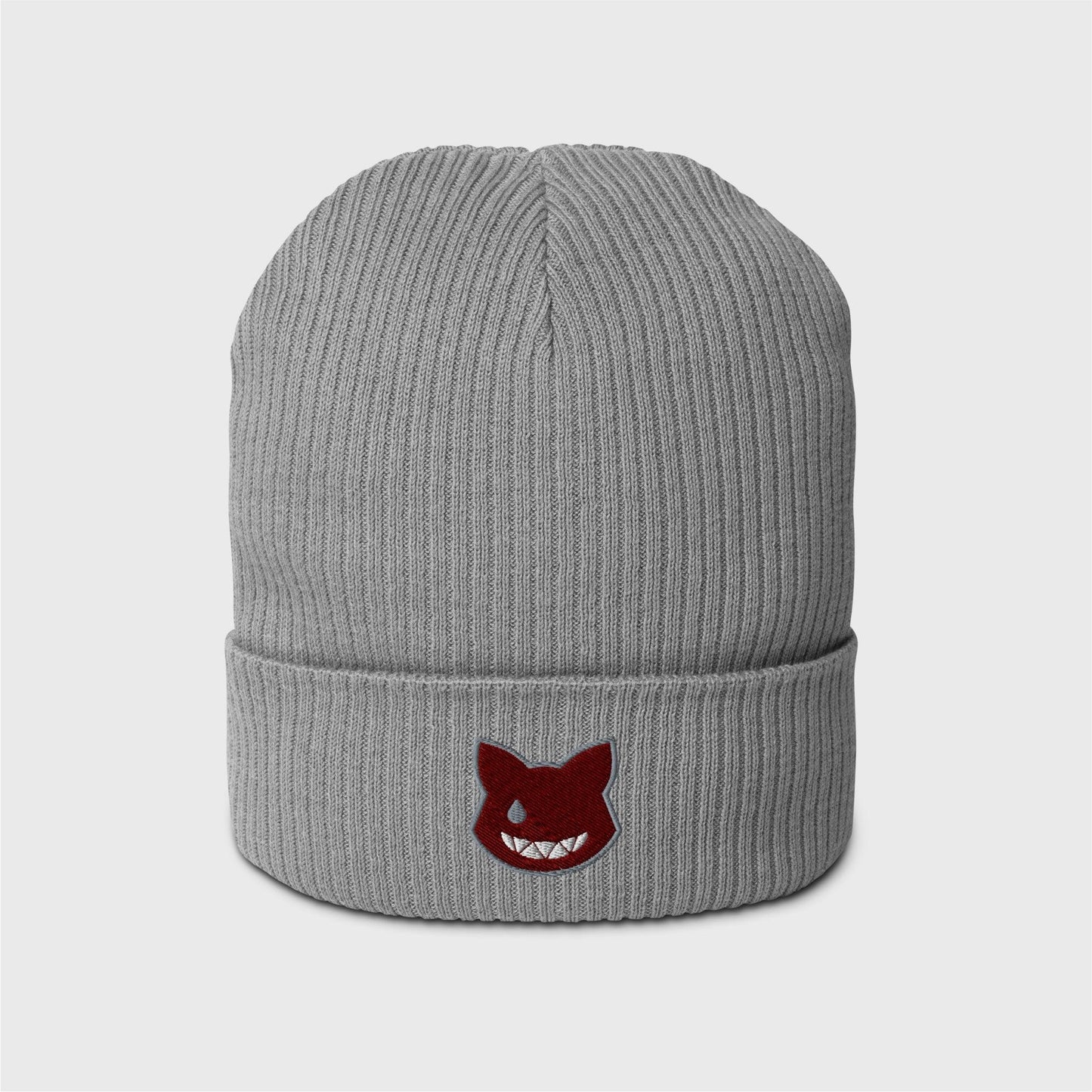 A light grey ribbed beanie featuring an embroidered wine red logo shaped as a cat’s head, lined in grey, showing only a left grey eye the shape of a water drop and a fanged white smile.