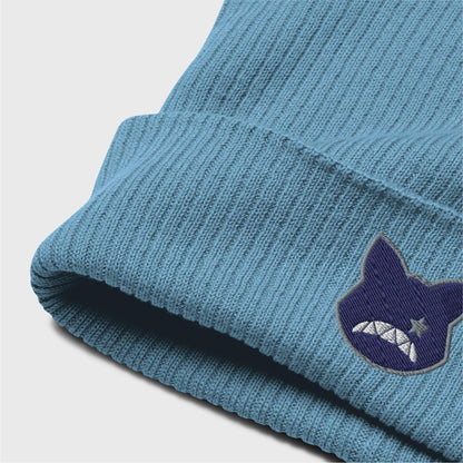 A detailed picture of the ribbed beanie showing the embroidered logo up close. you can see the organic cotton texture of the beanie folded up