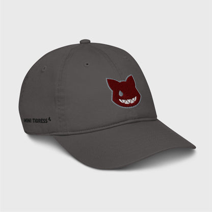 A side view of the grey cap showing the embroidered logo at the front and black letters on the right side of the cap at the bottom saying "Mini Tigress”.